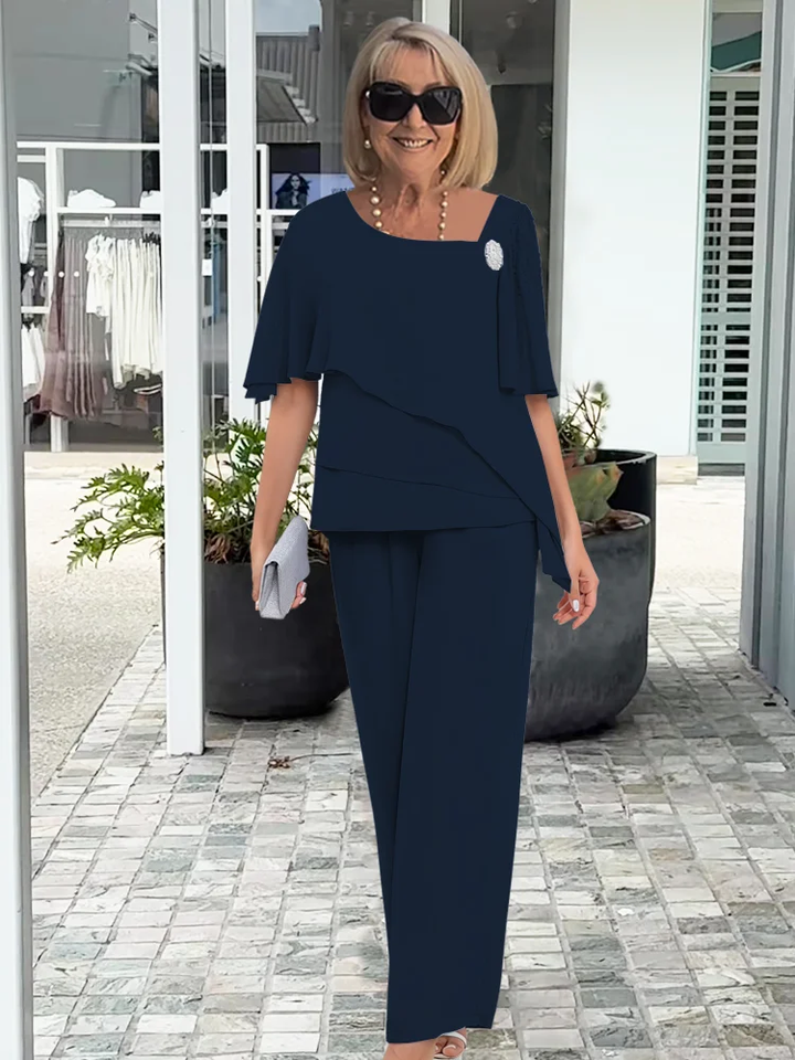Chic women's formal wear set featuring a flowy cape top and tailored trousers for an elegant silhouette.