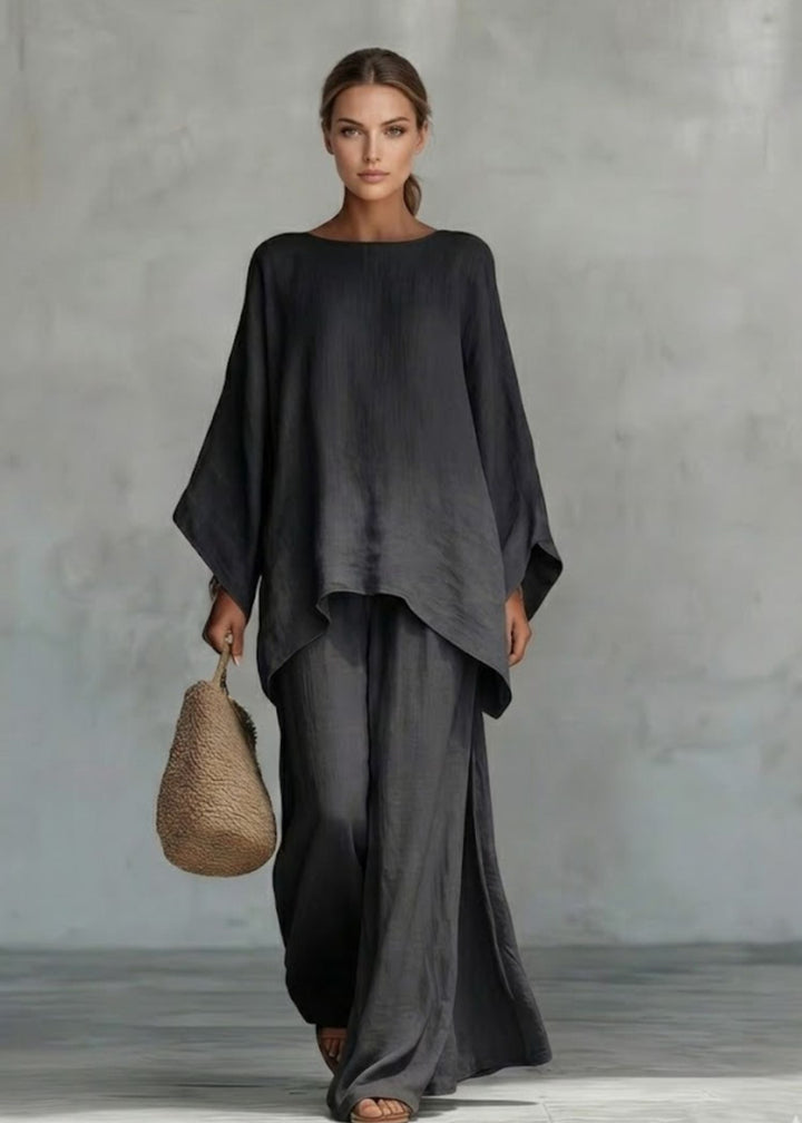 Monochromatic women's two-piece outfit with an elegant cape top and comfortable wide-leg pants for summer elegance.