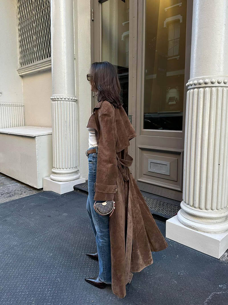 View of a women's rich brown belted trench coat, a versatile and elegant outerwear piece.