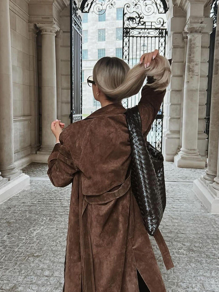 Close-up of the belted detail on a women's warm trench coat, emphasizing fall fashion style.