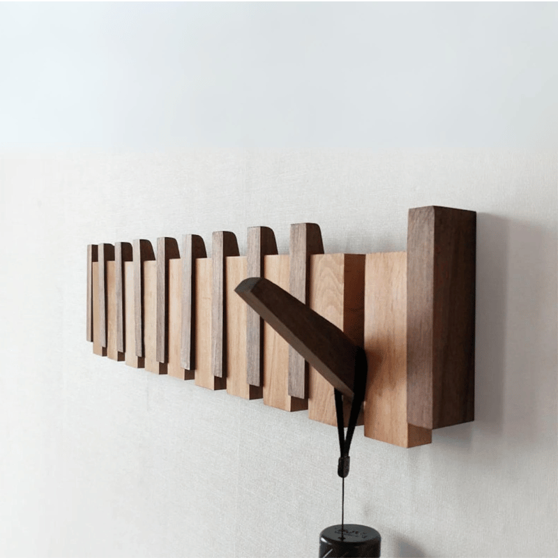 "Elegant wooden coat rack with magnetic hooks, crafted from walnut and beech, offering a sleek, natural aesthetic."