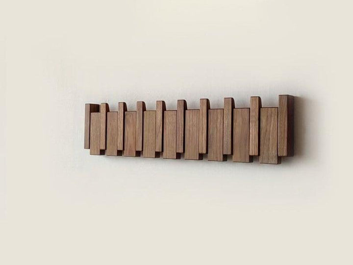 "Elegant wooden coat rack with magnetic hooks, crafted from walnut and beech, offering a sleek, natural aesthetic."