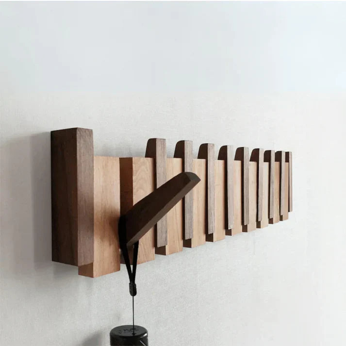 Modern wooden coat rack, piano key style. Wall-mounted entryway organizer with folding hooks.