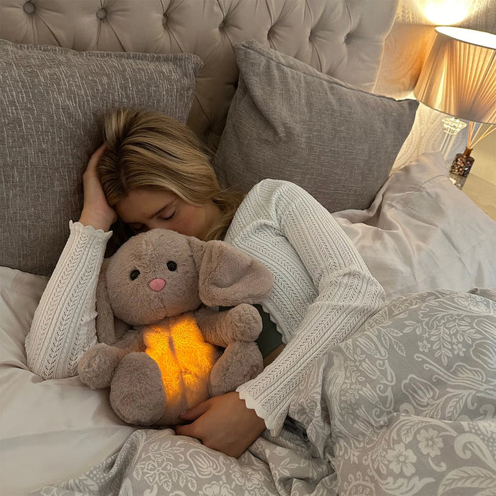 Cute stuffed animal sleep aid providing anxiety relief with soothing sounds & soft glowing lights for comfort.