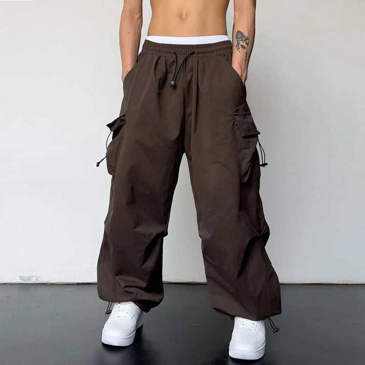 Men's cargo parachute pants, baggy loose fit, drawstring waist. Essential streetwear and Y2K fashion utility pants.