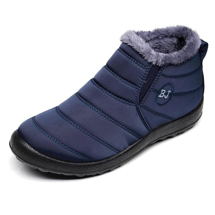 Detail of the waterproof material and stitching on a men's outdoor winter boot, ensuring warmth and protection from snow.