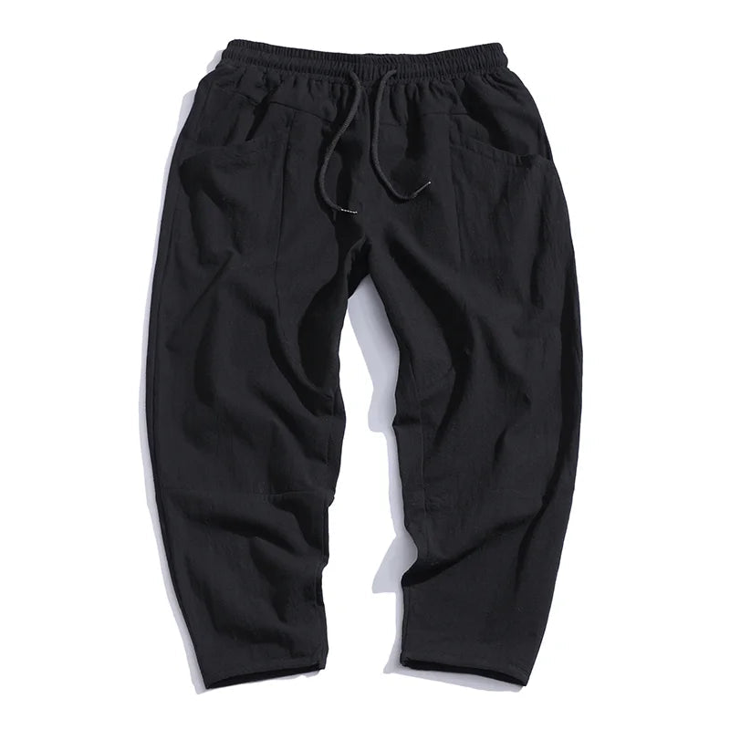 Black men's cropped drawstring chino pants, stylish, comfy, and versatile.