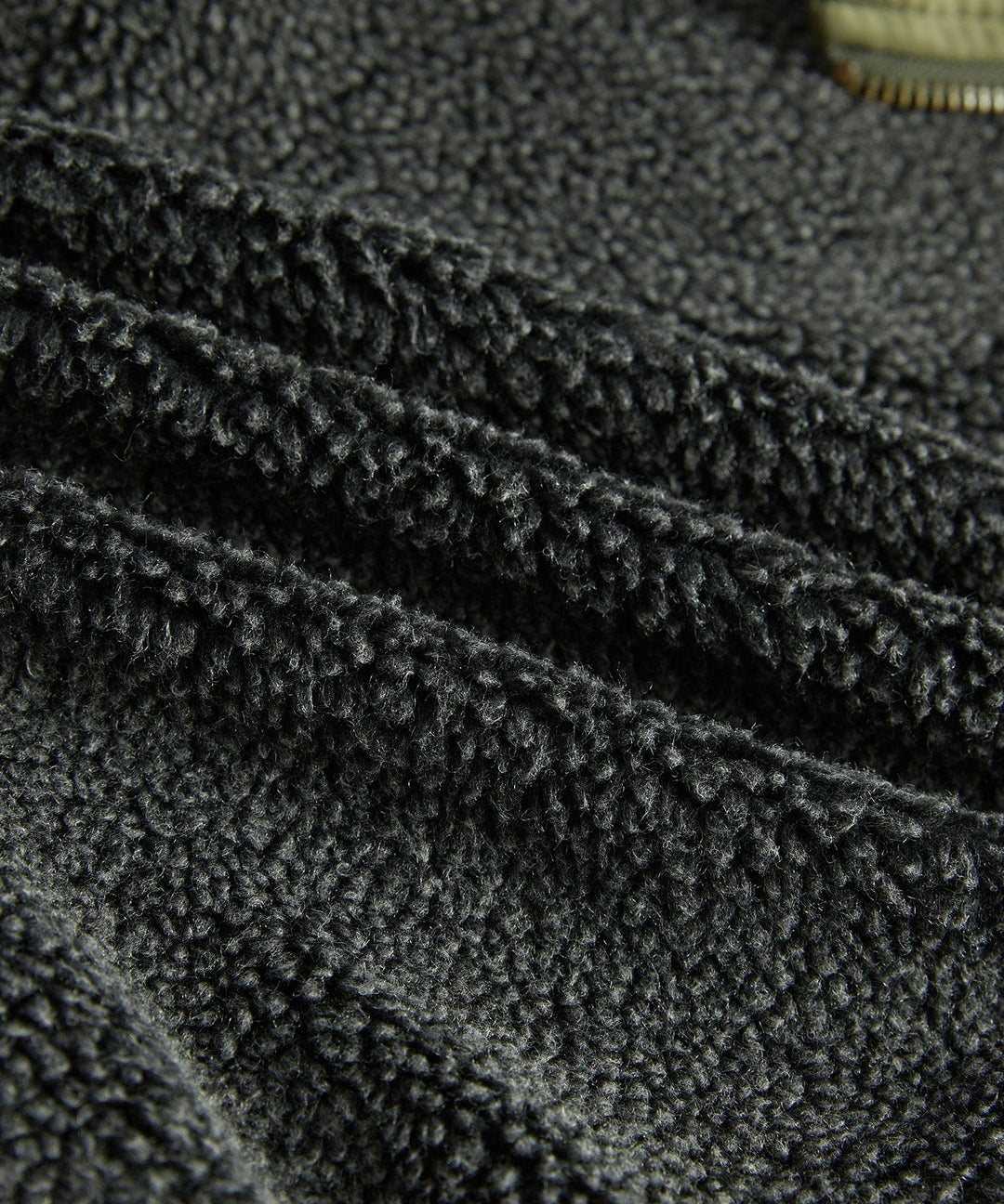 Detail of the robust stitching and pocket flap on the men's military-style utility jacket.