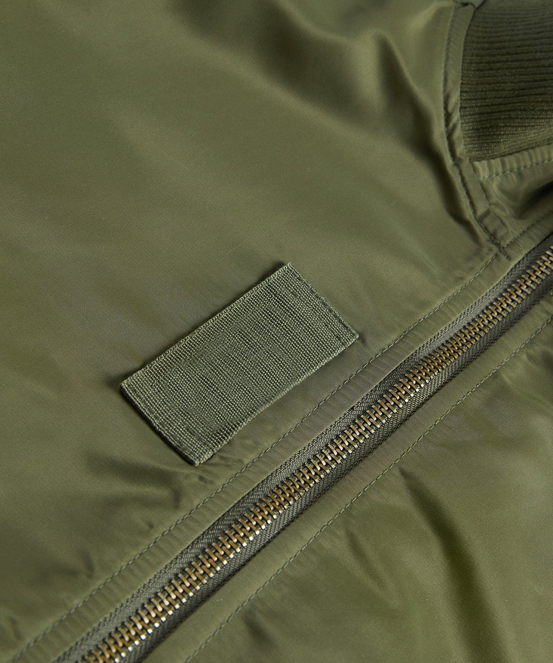 Detail shot of the ribbed cuff and sleeve pocket on a men's utility bomber jacket for outerwear.