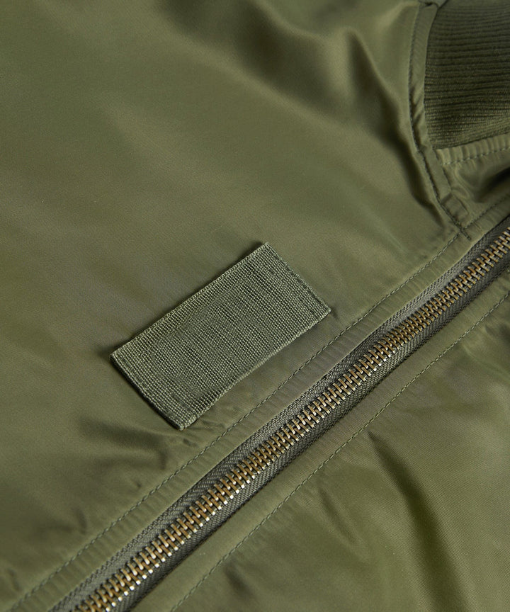Detail shot of the ribbed cuff and sleeve pocket on a men's utility bomber jacket for outerwear.