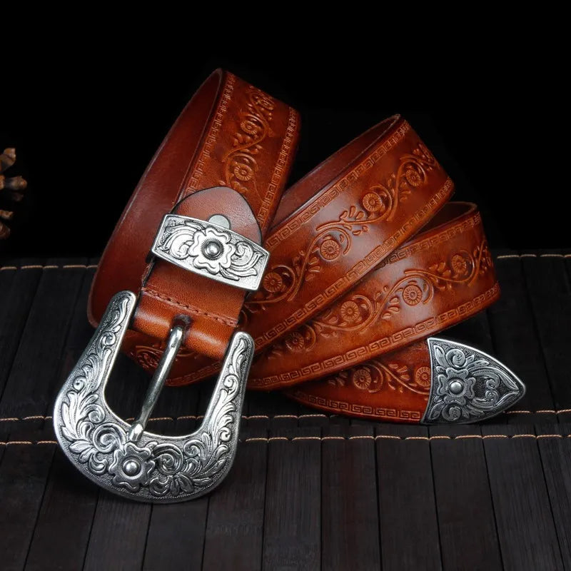 Men's engraved western belt with intricate floral scroll pattern and a decorative metal buckle. Rustic fashion accessory.