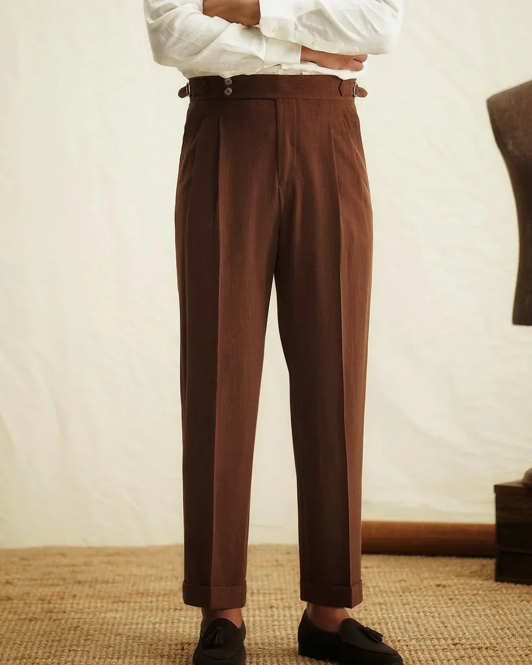 Detail of the side buckle on men's tailored high-waisted trousers, highlighting quality and design.