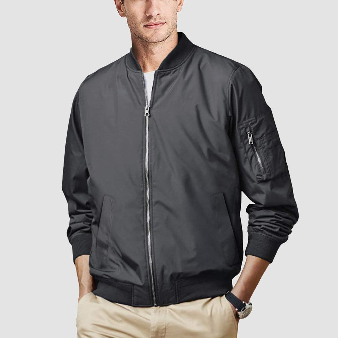 Man checking his phone, wearing a modern men's bomber jacket, casual everyday scene