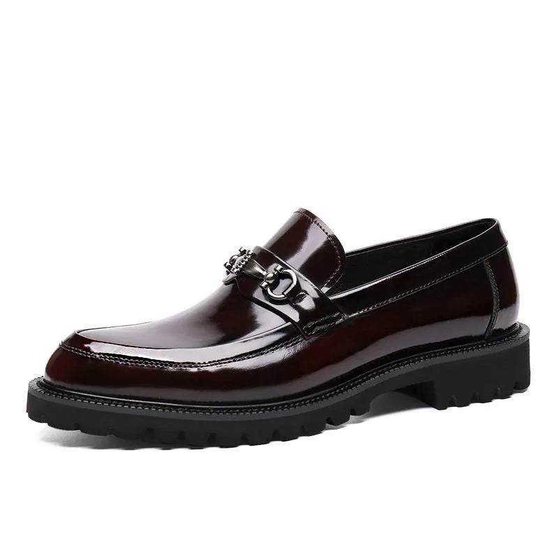 Dynamic angle of men's polished burgundy loafers. Stylish metal bit dress shoes for any formal occasion.