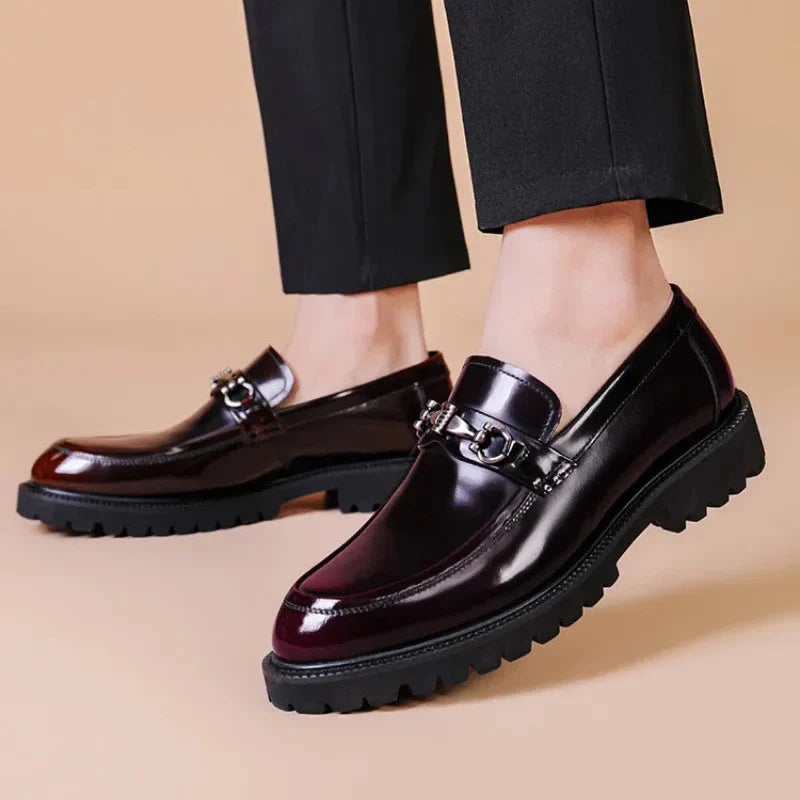 Detailed view of the polished black leather texture on men's formal loafers. Classic slip-on dress shoes.