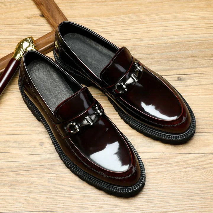 Pair of classic men's polished black leather loafers. Formal slip-on dress shoes with metal bit detailing.