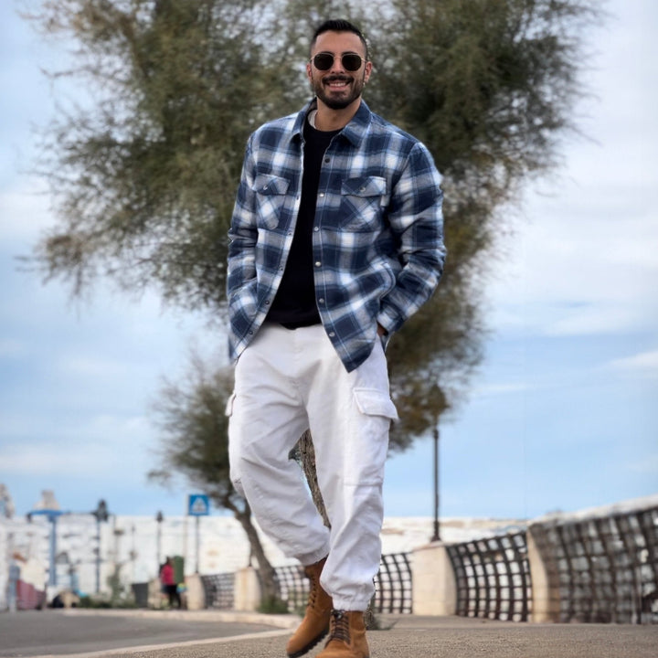 Close-up of the plaid fabric on a men's quilted flannel jacket, a staple for fall fashion