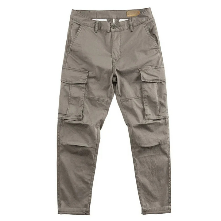 Close-up of a men's relaxed fit cargo pant pocket, highlighting stitching and button closure.