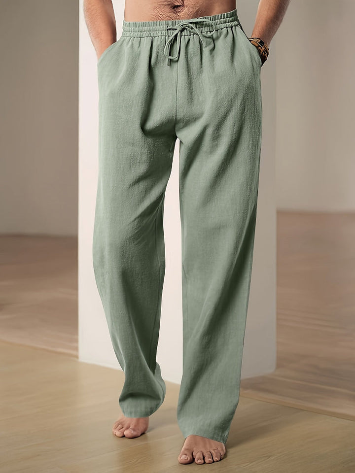 Relaxed fit men's drawstring pants featuring an elastic waist and functional side pockets.