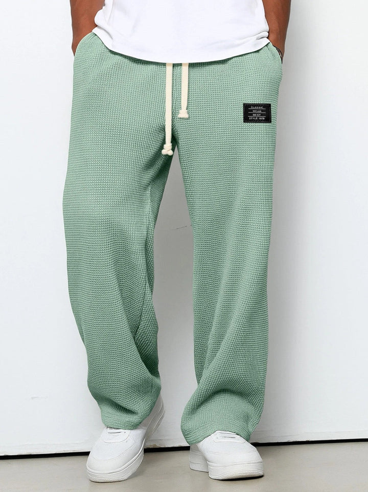 Man walking comfortably in Stuart loose fit drawstring chino pants, perfect for a relaxed, casual look.
