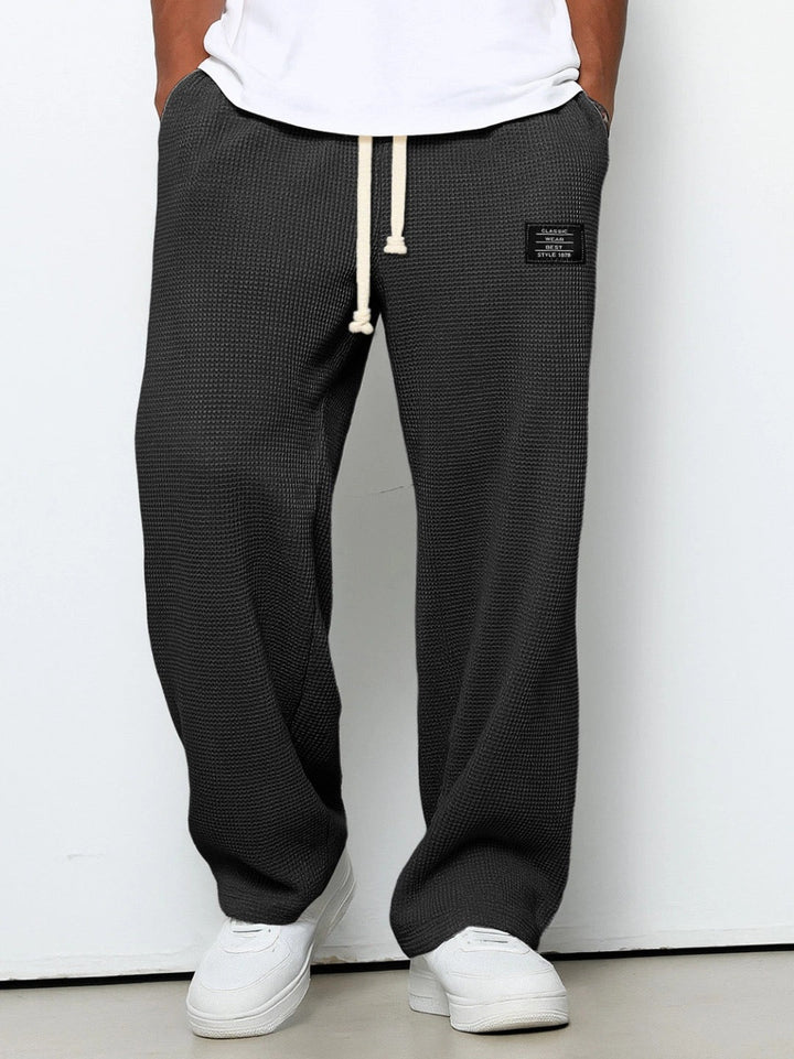 Detailed shot of the comfortable drawstring waistband on Stuart men's loose fit chino pants. Everyday wear.