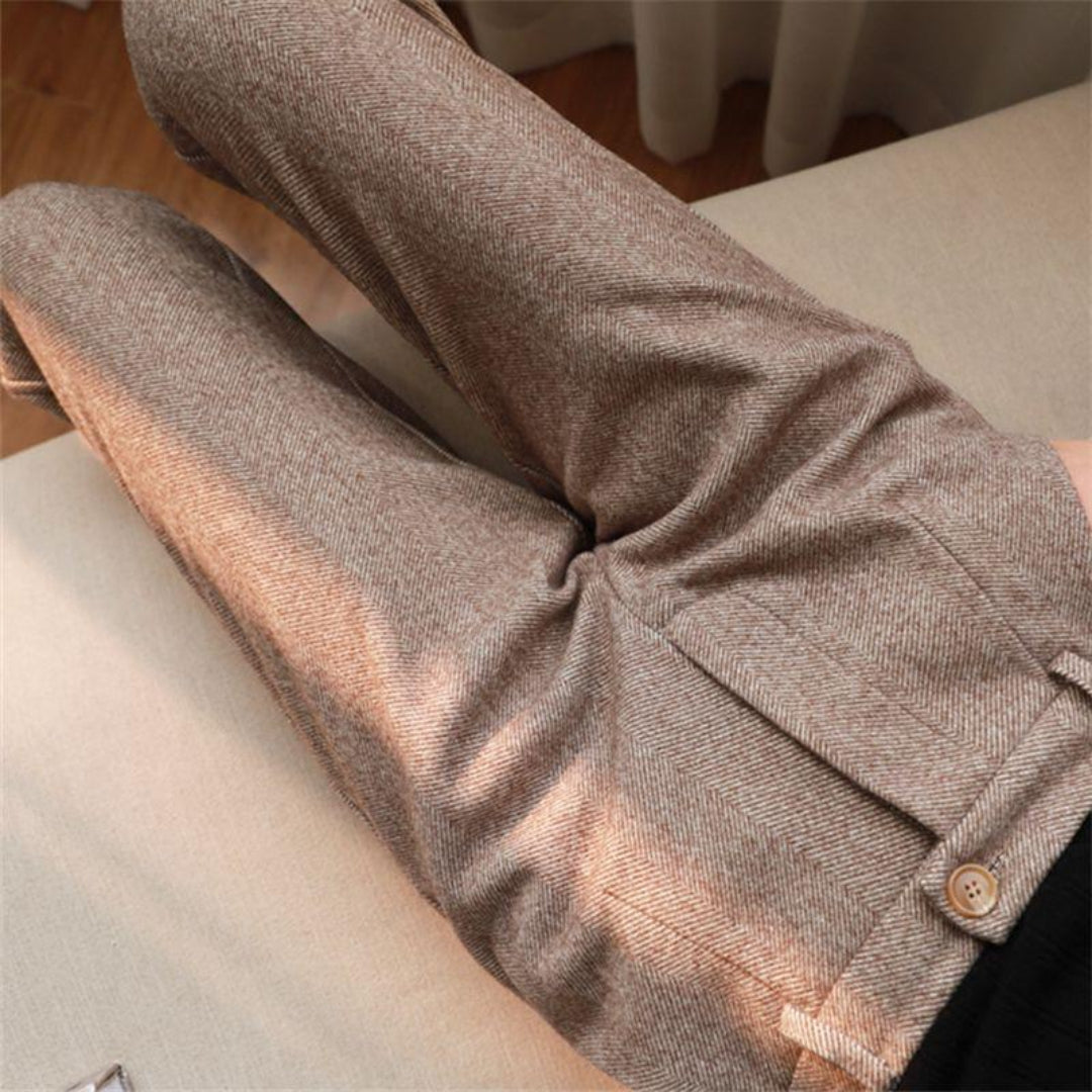 Stack of men's ankle-length tailored pants in various colors including beige, navy, and black
