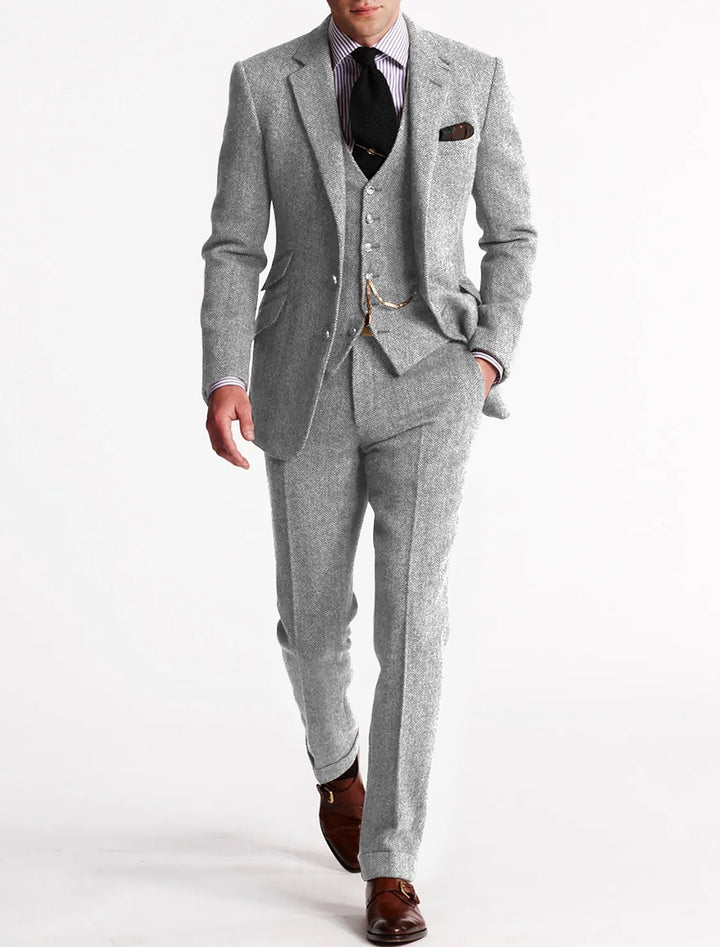 Close-up of the tweed fabric on a men's three-piece suit, highlighting the texture and quality for formal wear.