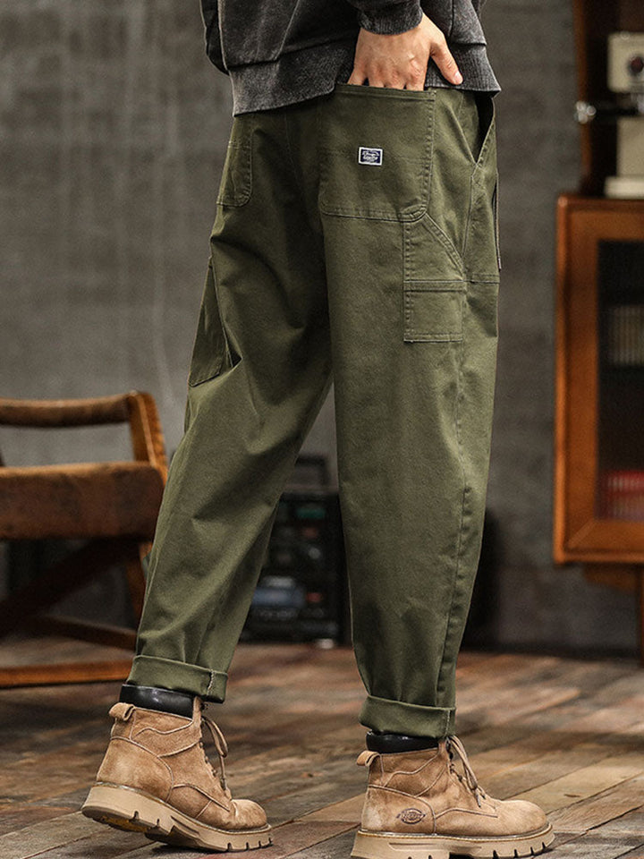 Navy blue men's vintage-inspired utility pants. Relaxed fit cargo trousers for comfortable casual wear.