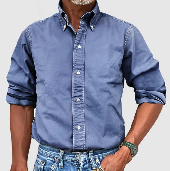 Close-up of men's vintage wash button down long sleeve shirt. Highlights solid color & fabric texture.