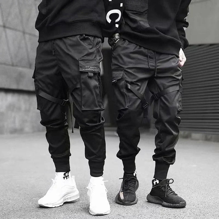 Black multi-pocket cargo pants for men, featuring a relaxed fit for urban hip-hop fashion.