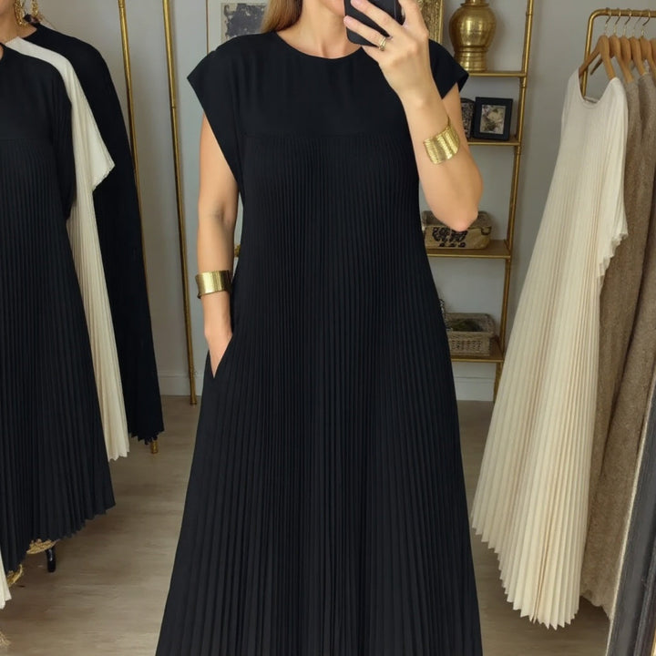 Woman walking in a flowing pleated maxi dress, perfect for a comfortable, elegant & versatile summer look.