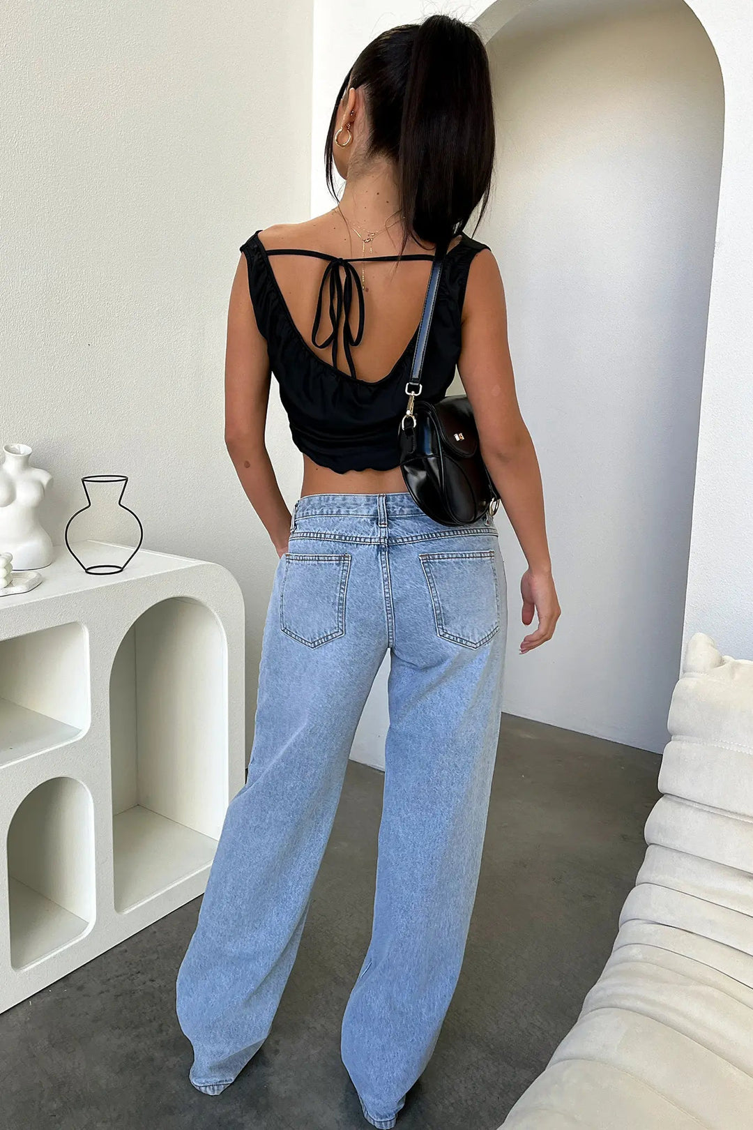 Model wearing women's relaxed straight-leg blue denim jeans, styled for casual everyday fashion.