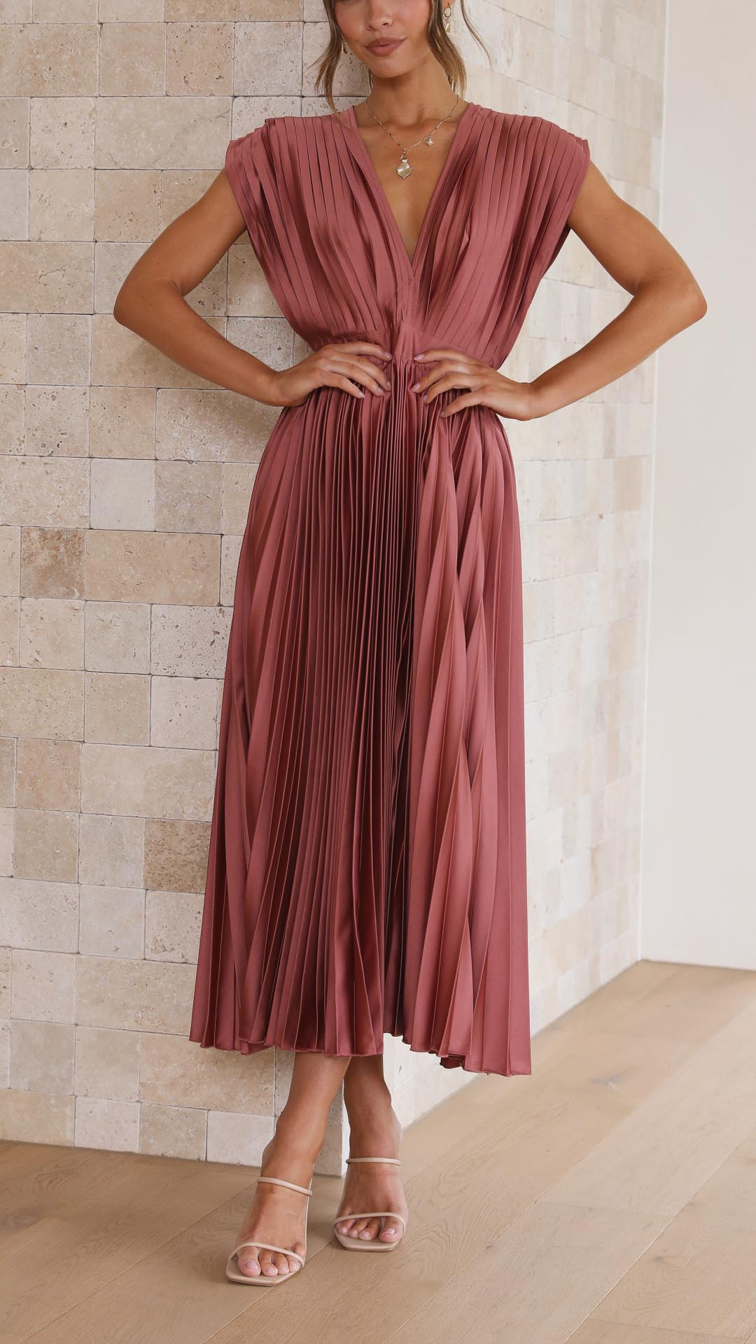 Silk pleated maxi dress with V-neck in rose red, featuring a high waist and elegant flowing pleats for a sophisticated look.