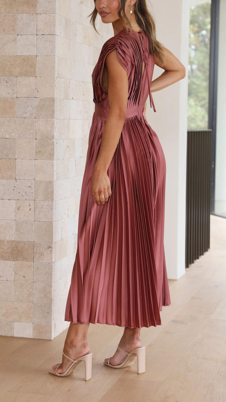 Silk pleated maxi dress with V-neck in rose red, featuring a high waist and elegant flowing pleats for a sophisticated look.