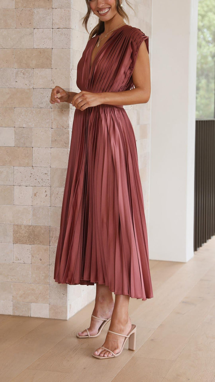 Silk pleated maxi dress with V-neck in rose red, featuring a high waist and elegant flowing pleats for a sophisticated look.