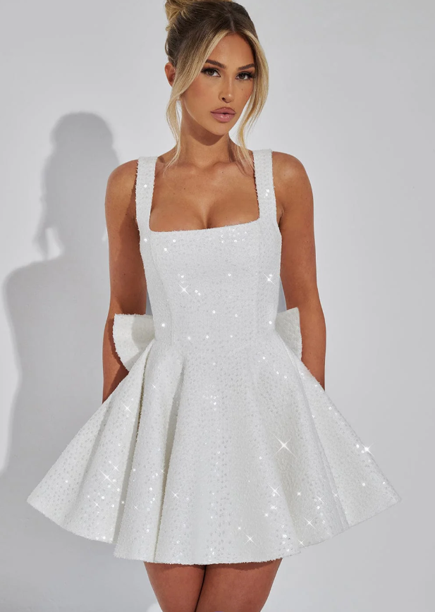 Shiny women's cocktail mini dress. Backless design with a decorative bow, perfect for glamorous parties.