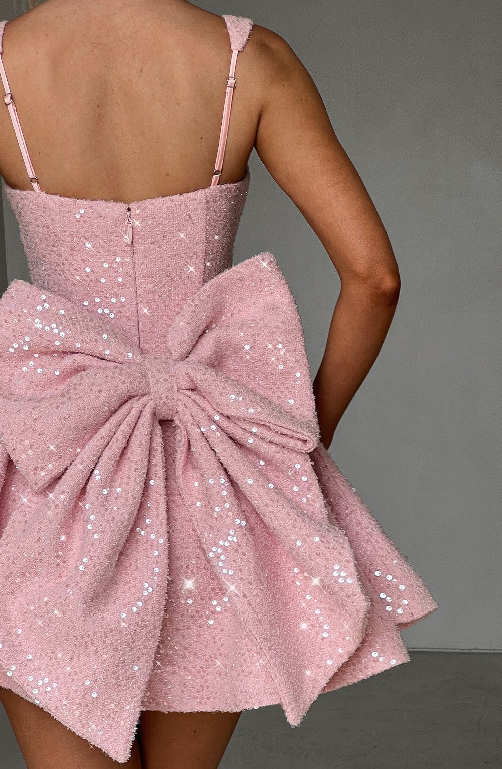 Women's glittering short party dress. Backless style with a chic bow, ideal for festive evening events.