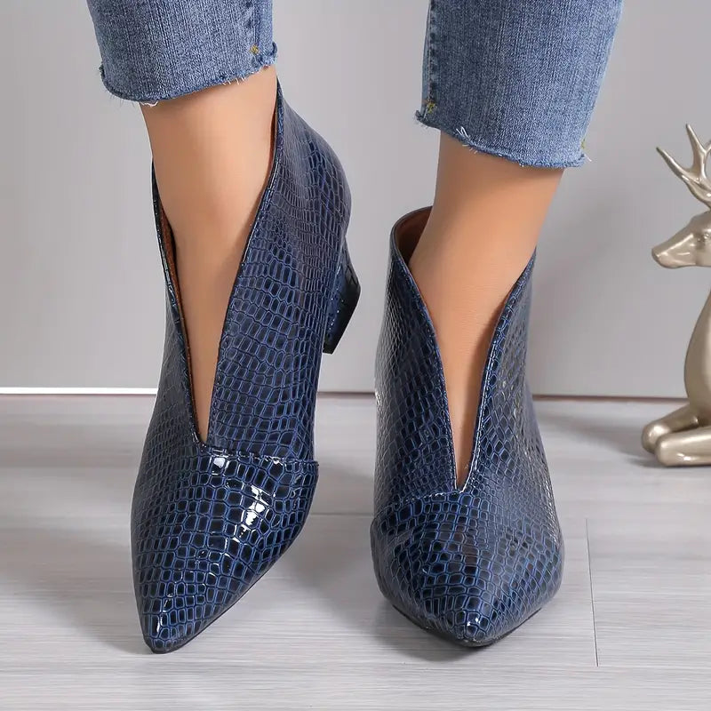 Stylish women's ankle boots with exotic reptile texture, perfect for fashion-forward winter outfits.
