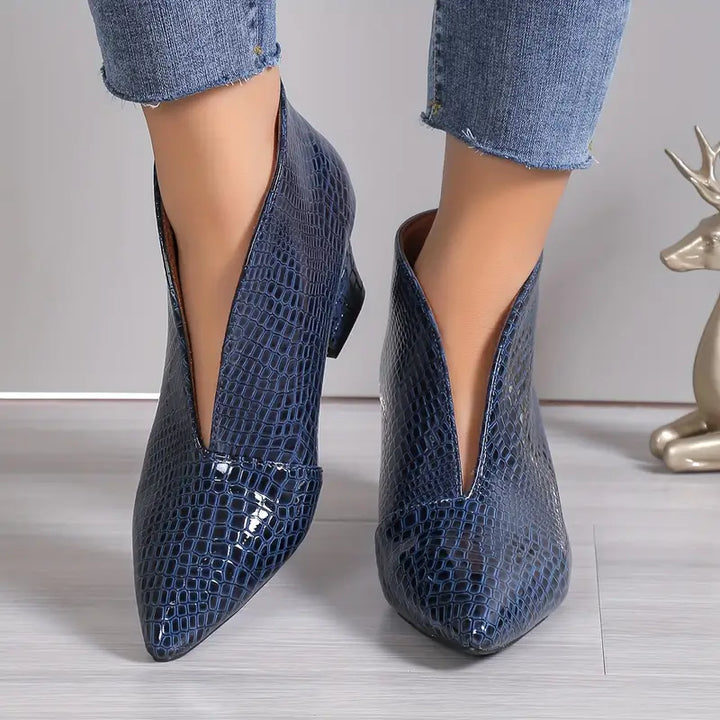Stylish women's ankle boots with exotic reptile texture, perfect for fashion-forward winter outfits.