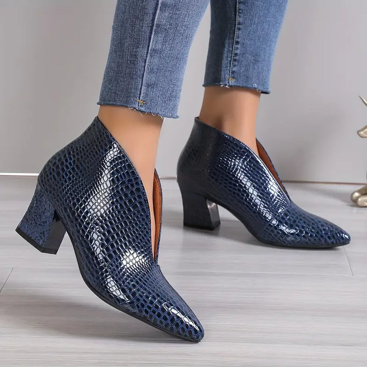 Close-up of reptile-textured upper on women's luxury ankle boots, showcasing unique pattern.