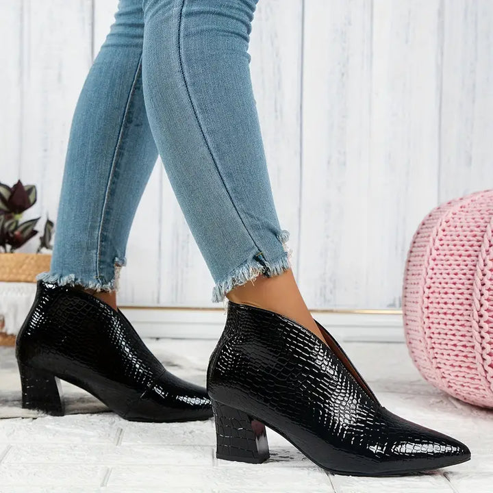 Group of women's ankle boots with reptile print, demonstrating various angles and stylish features.