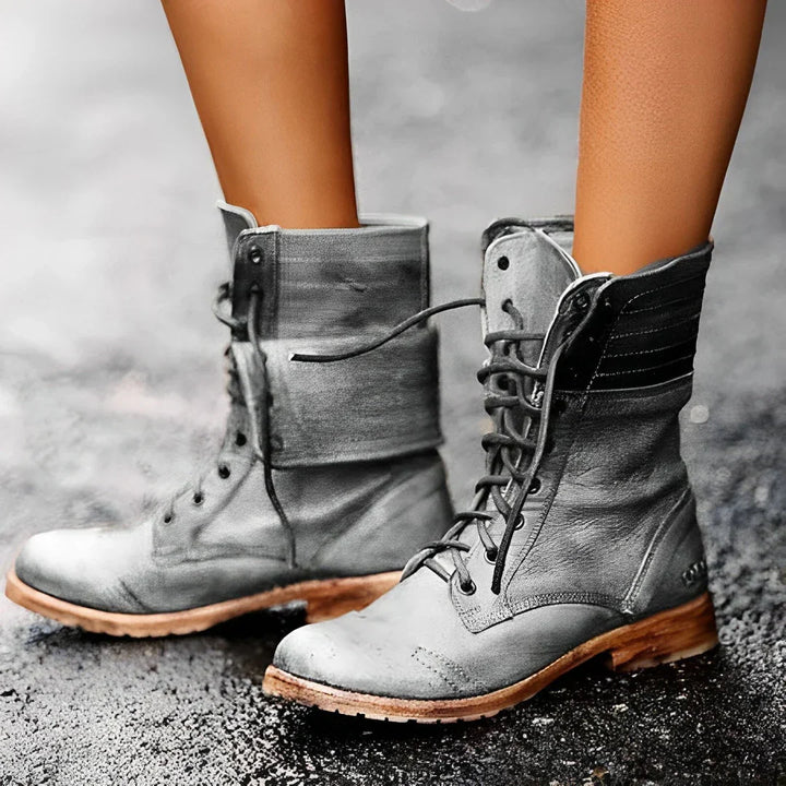 Fashionable women's ankle combat boots in black, featuring lace-up design & sturdy build for rugged wear