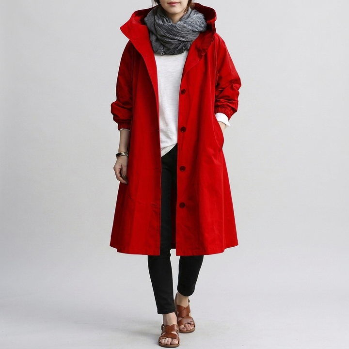 Chic oversized women's raincoat with a hood. Stylish outerwear for fashionable wet weather protection.