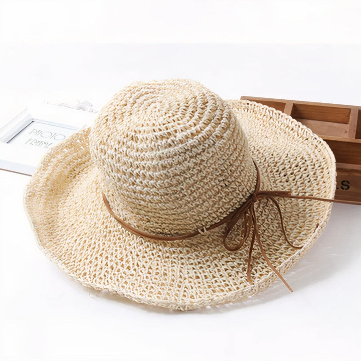 Elegant women's straw sun hat with a wide brim, ideal vacation accessory & stylish woven beachwear.