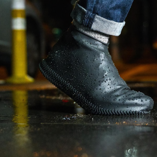 "Waterproof silicone shoe covers, anti-slip, foldable, unisex, shown covering shoes, durable and portable for any weather."