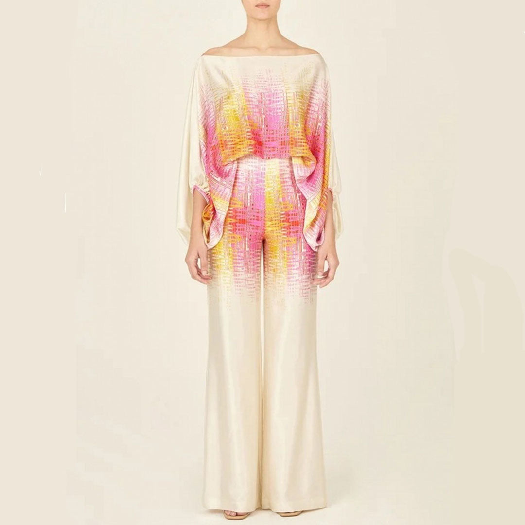 Woman enjoying vacation in an artistic one-shoulder printed two-piece pants set. Comfortable & chic resort wear.
