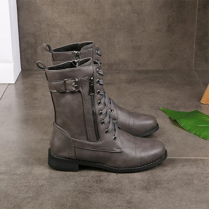 Several pairs of women's combat boots arranged, emphasizing various angles of the side zip and style.