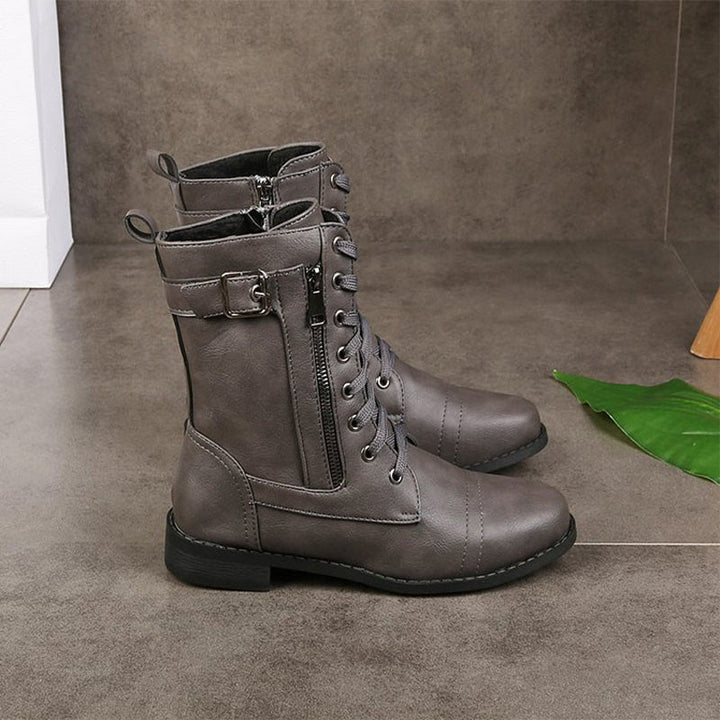 Several pairs of women's combat boots arranged, emphasizing various angles of the side zip and style.