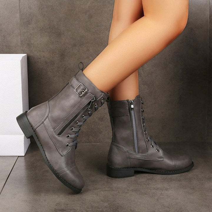 Close-up of the laces and eyelets on women's combat boots, complementing the side zip design.
