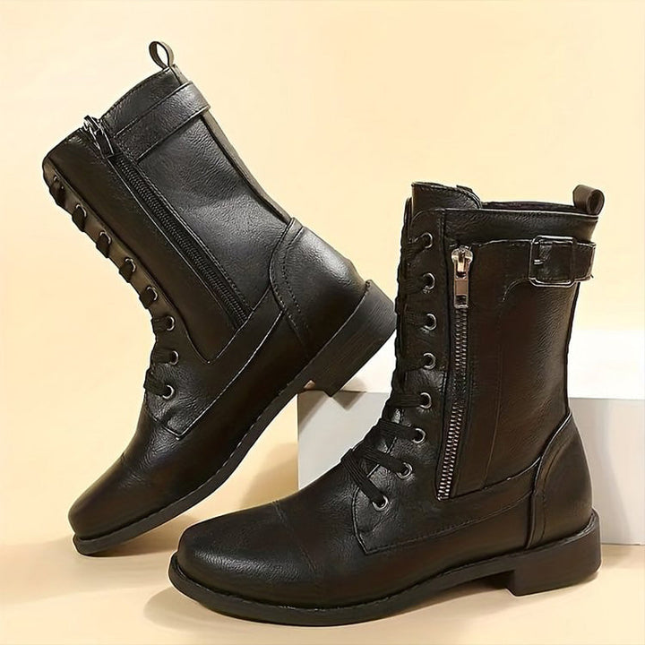 Pair of women's stylish combat ankle boots, black leatherette with lug sole, perfect for casual wear.